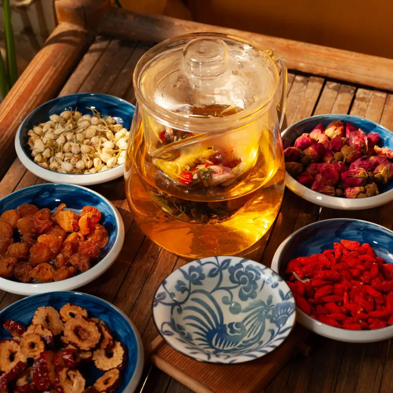 玻璃壺裡的花草茶,周圍擺著枸杞、紅棗等乾料